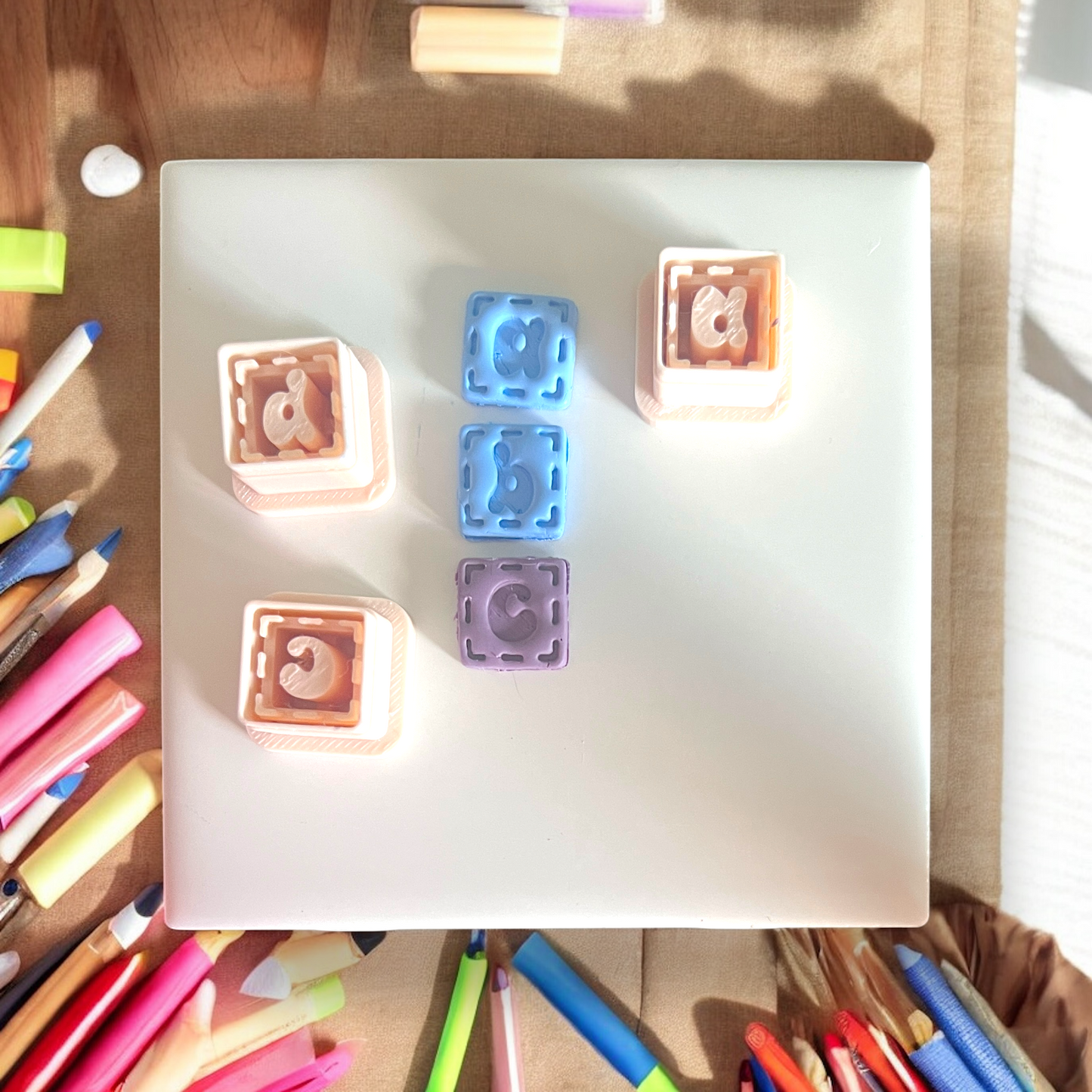 Colorful letter stamps on a white paper with markers around