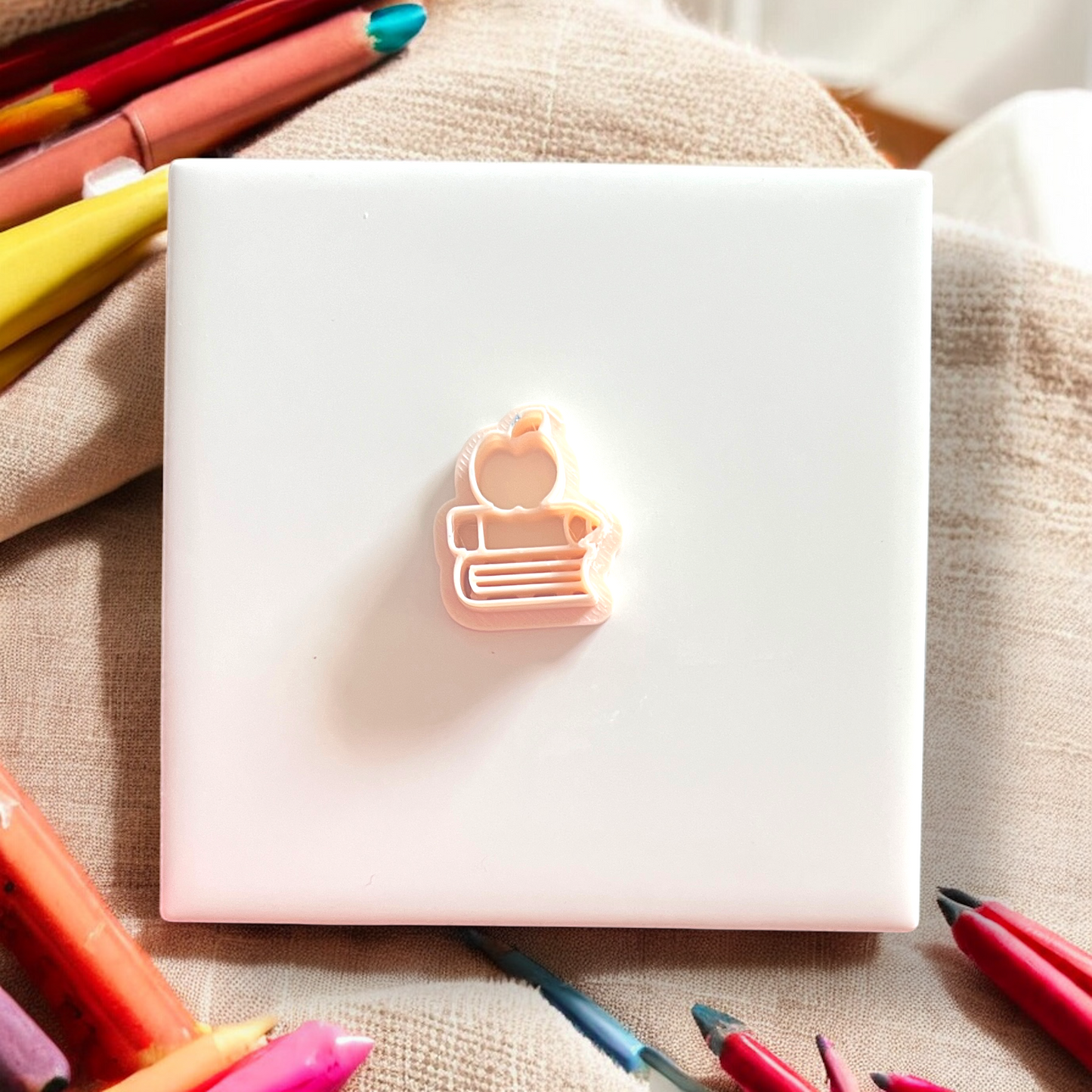 Notebook with a light on top, surrounded by colorful markers on a textured surface