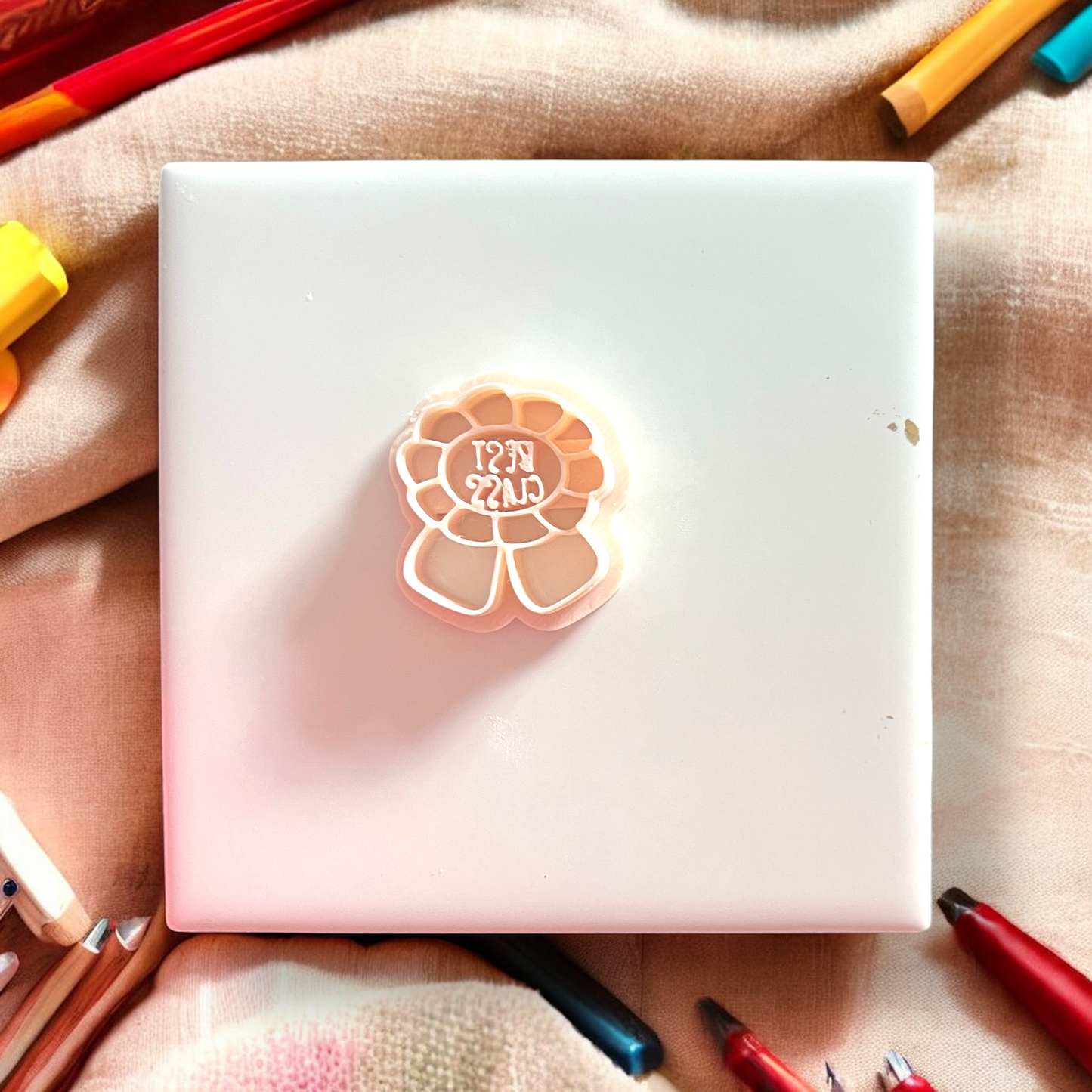 White notebook with a decorative sticker on a surface with colorful pens