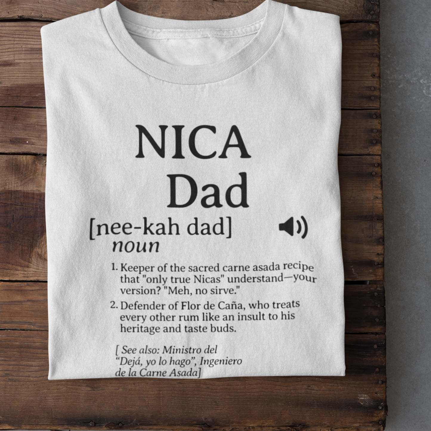Flat lay of white Nicaraguan Dad t-shirt with bold, witty text, neatly displayed on a rustic wooden surface.