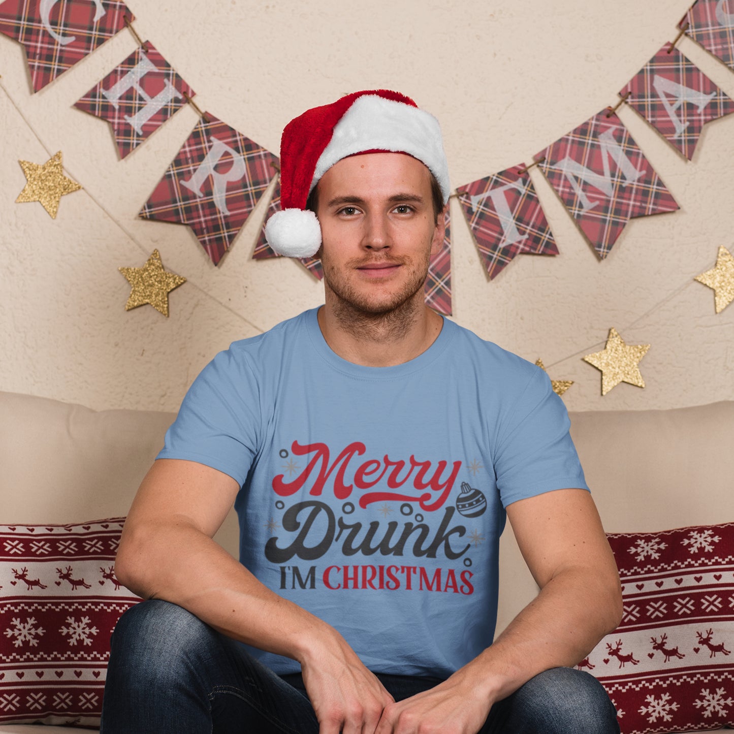 Boy wearing a light blue "Merry Drunk I’m Christmas" t-shirt with festive graphics, paired with a Santa hat for holiday celebrations.