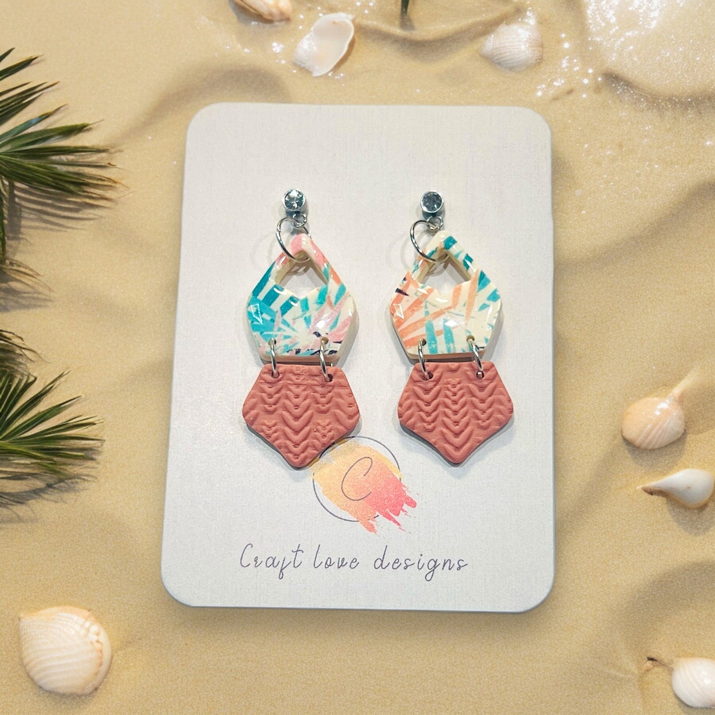 Handmade multicolor polymer clay earrings, elegantly mounted on Craft Love Designs' branded card with beach-themed details.