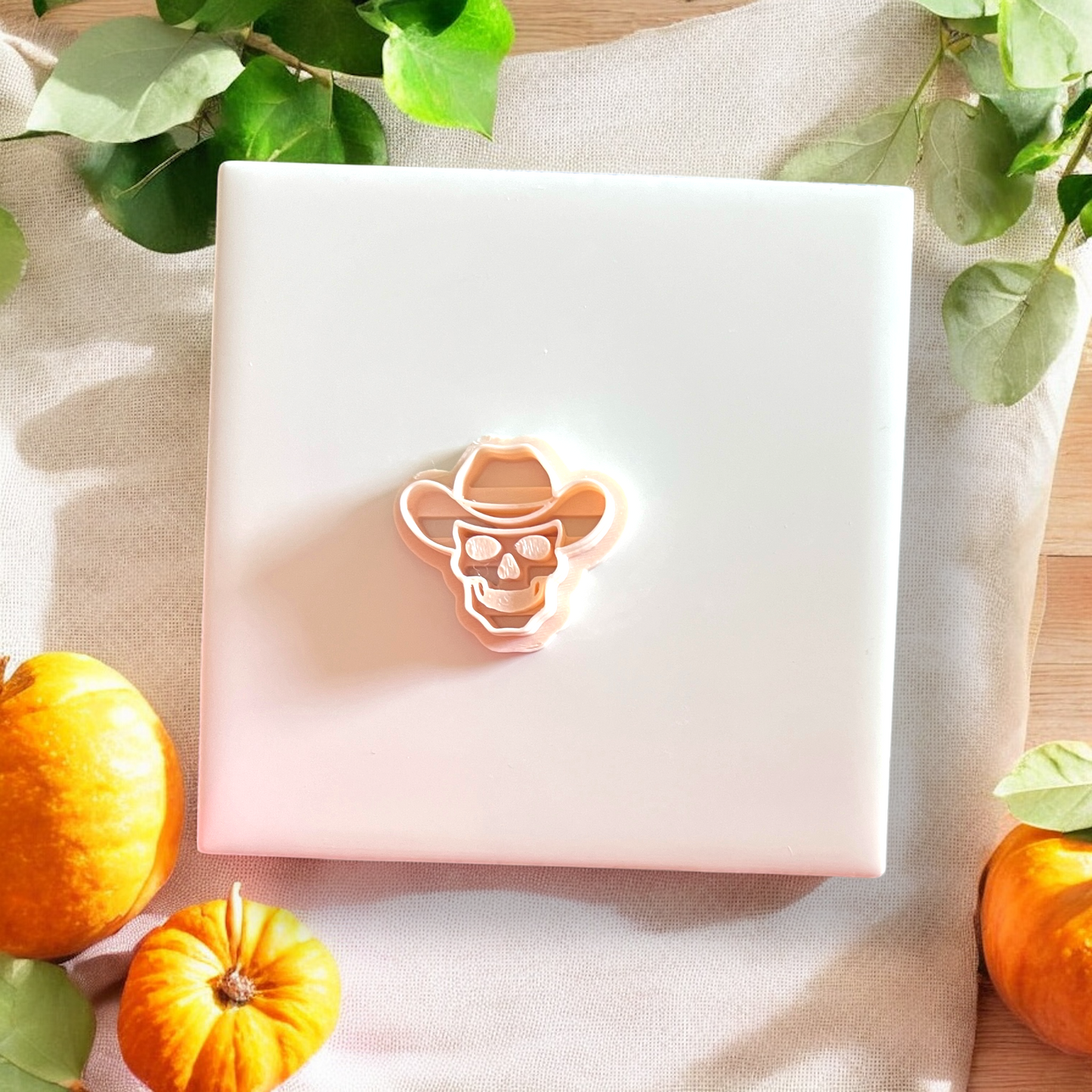 Cowboy skull clay cutter resting on embossed tile with fall props