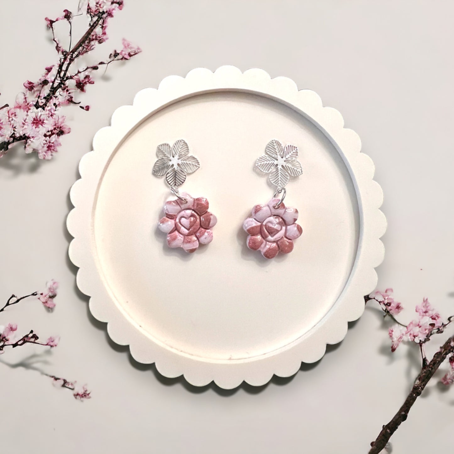 Romantic pink heart-centered flower earrings with silver clover-like tops, perfect for adding feminine flair.