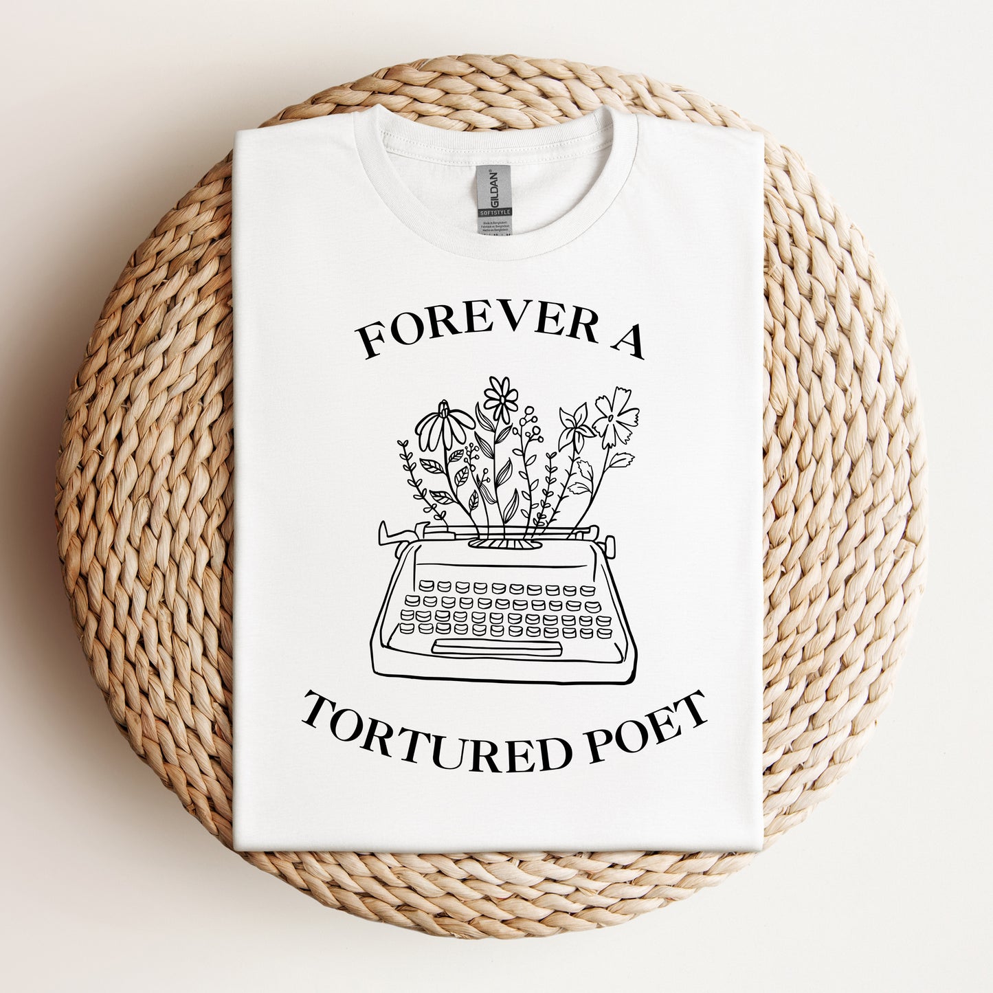 White t-shirt with a black line art of a typewriter with flowers and the text "Forever a Tortured Poet," inspired by the Tortured Poets album.