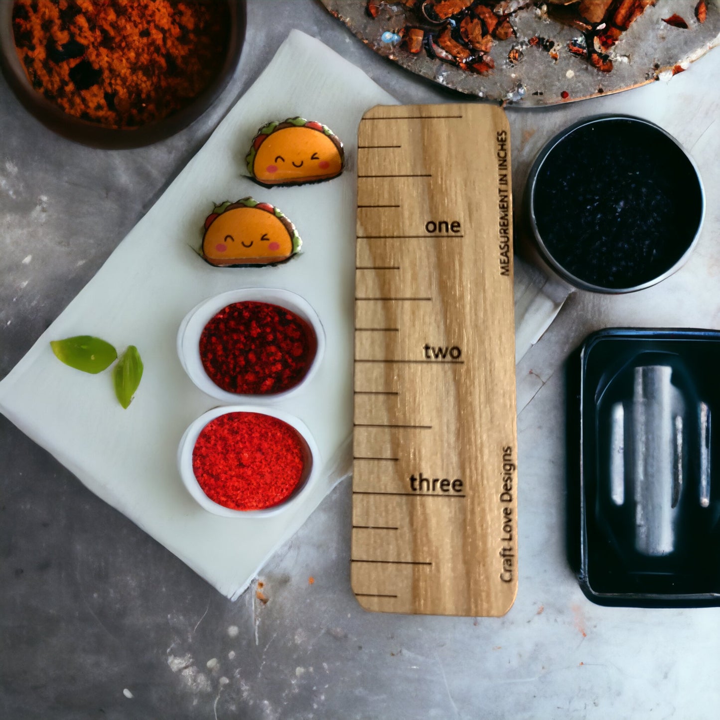 Orange-y taco stud earrings with adorable smiles, placed next to vibrant bowls of spices and ingredients, showcasing the fun Taco Tuesday vibe.
