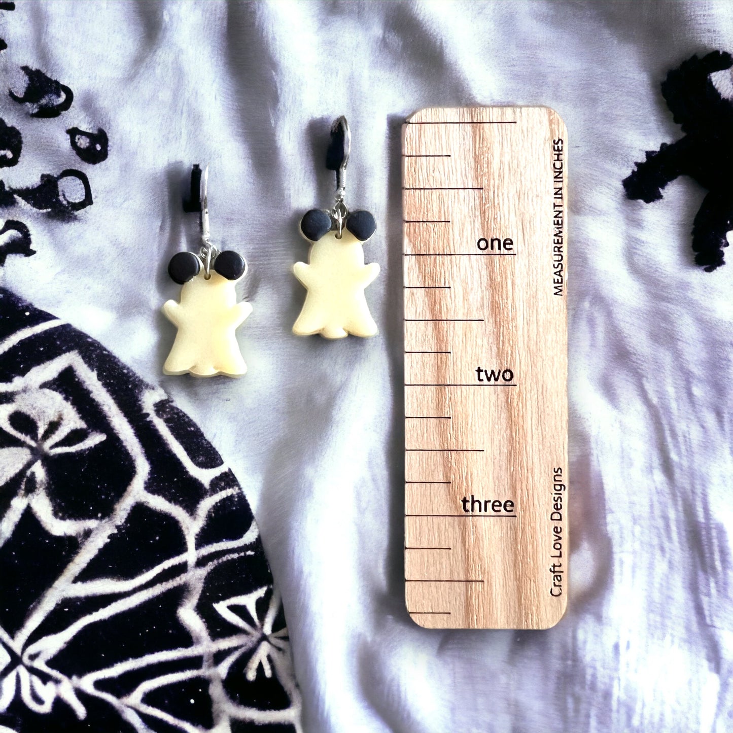 White ghost earrings featuring mouse ears and glow-in-the-dark magic, shown next to a ruler for size comparison and detail display.