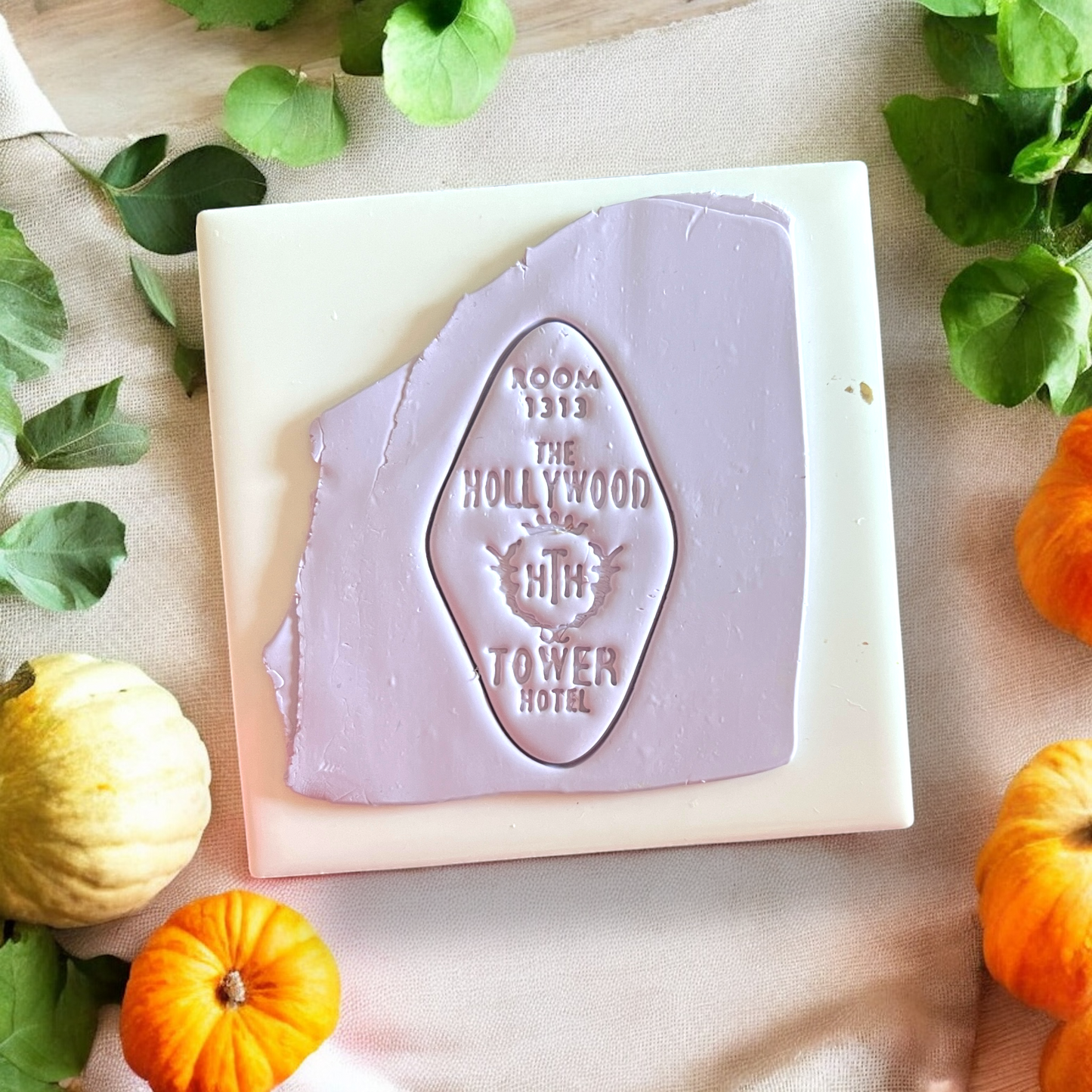 Embossed Room 1313 Hollywood Tower Hotel design in purple clay with mini pumpkins and leaves.
