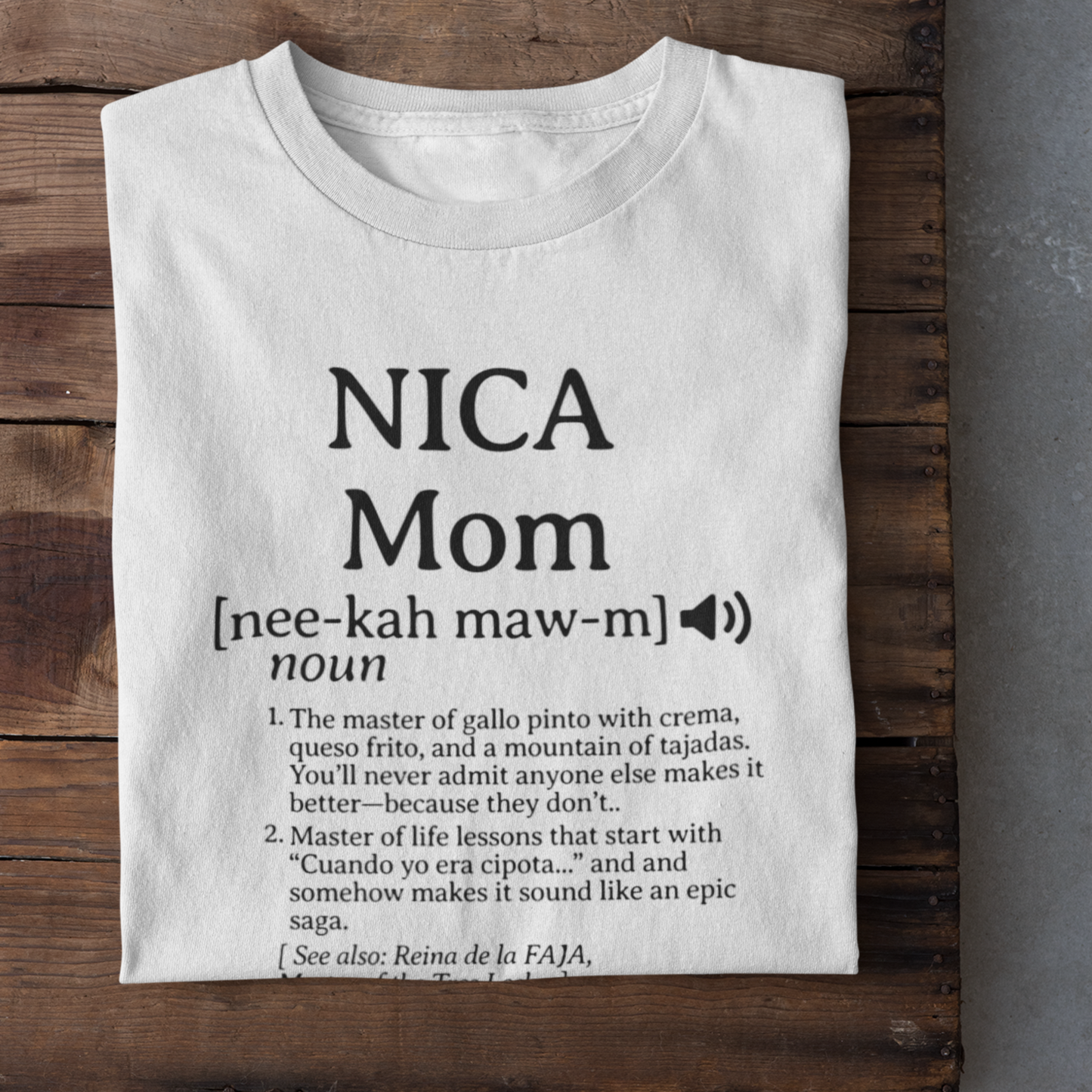 Flat lay of white Nicaraguan Mom t-shirt featuring humorous text, neatly displayed on a rustic wooden background.