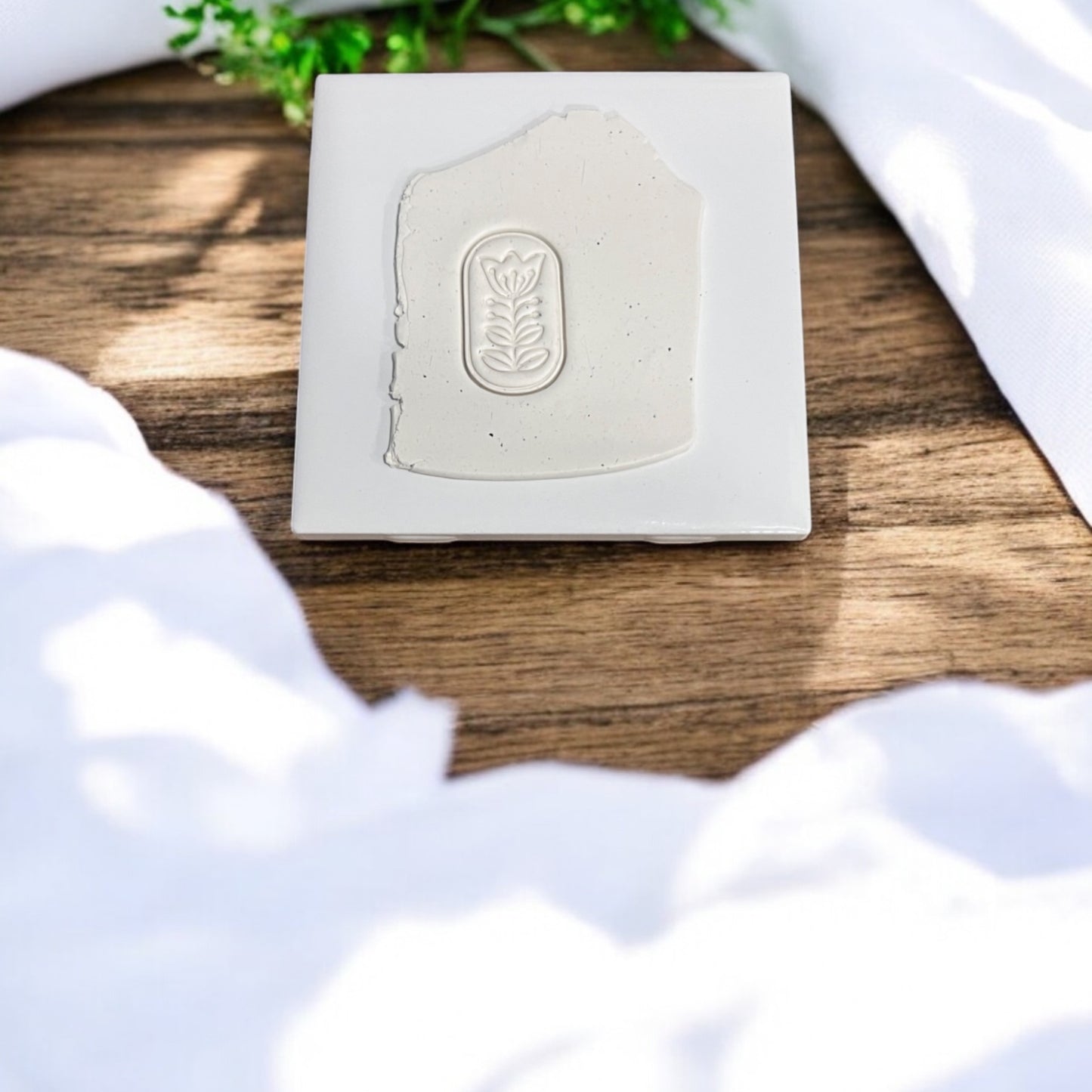 Scandinavian floral design embossed into white polymer clay slab on ceramic tile
