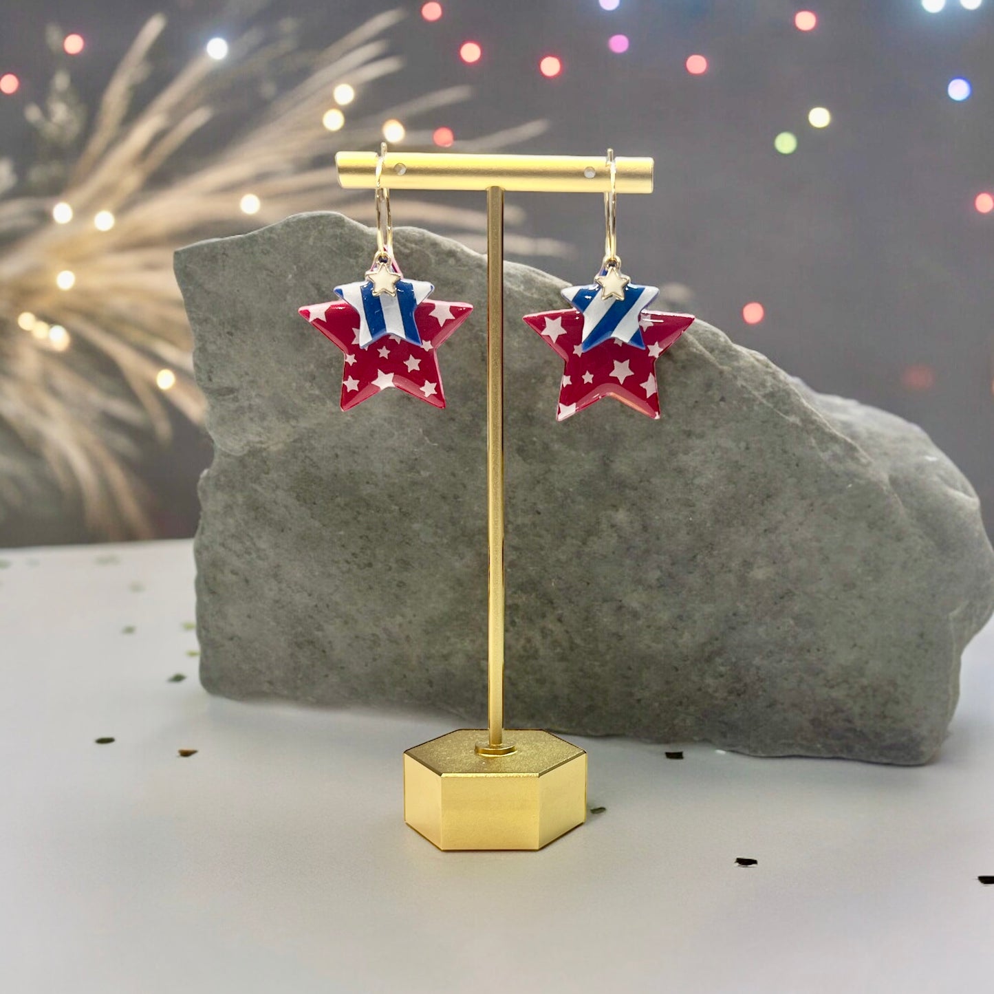 Handmade polymer clay star earrings featuring red, white, and blue layers with gold accents, perfect for 4th of July celebrations.