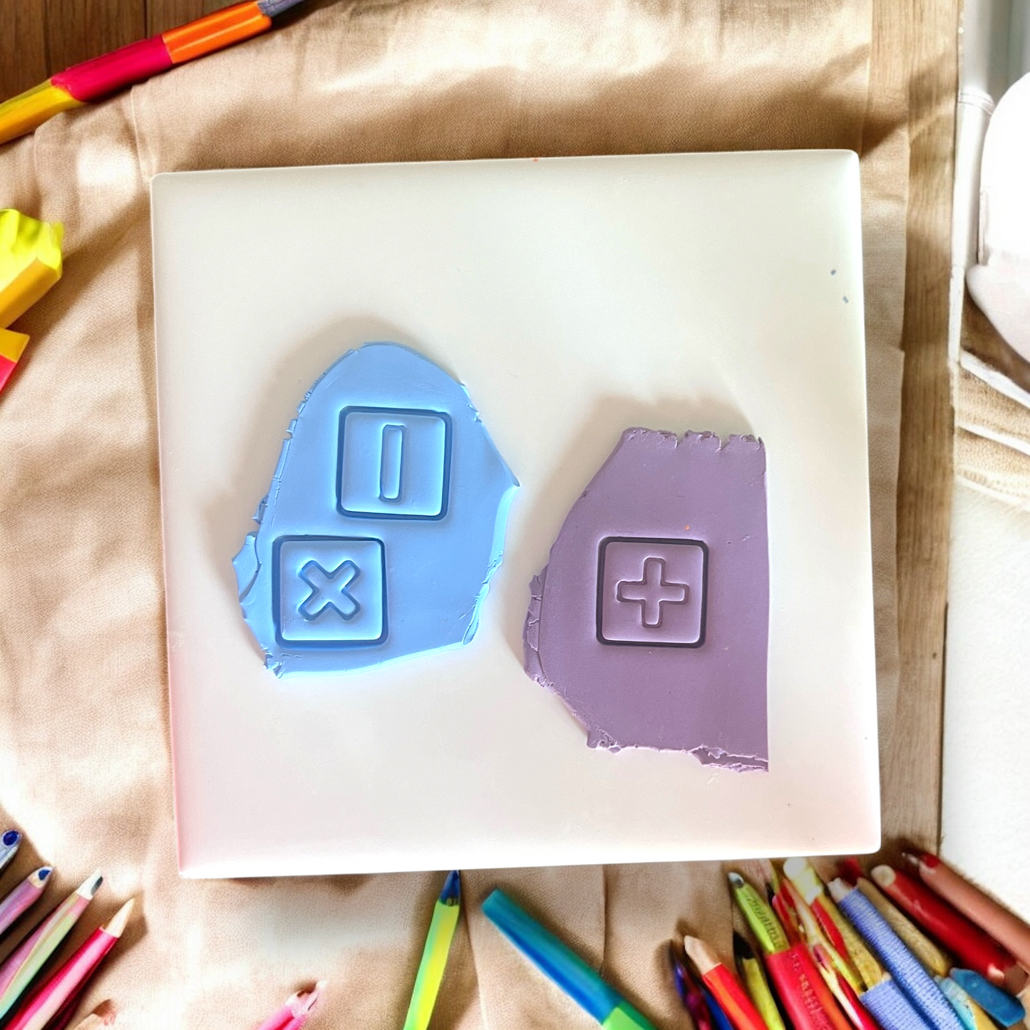 Blue and purple clay slabs with embossed math symbols including plus, minus, and multiply shapes.