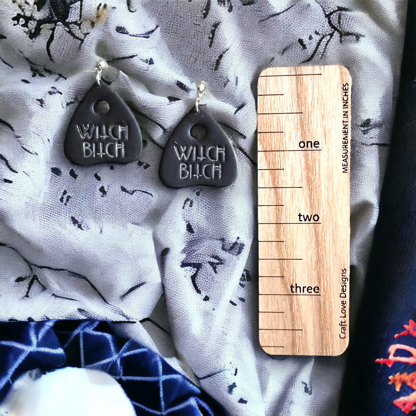 Black spooky dangle earrings with "Witch B***" engraved in silver, triangular Ouija-inspired design for a bold Halloween vibe.