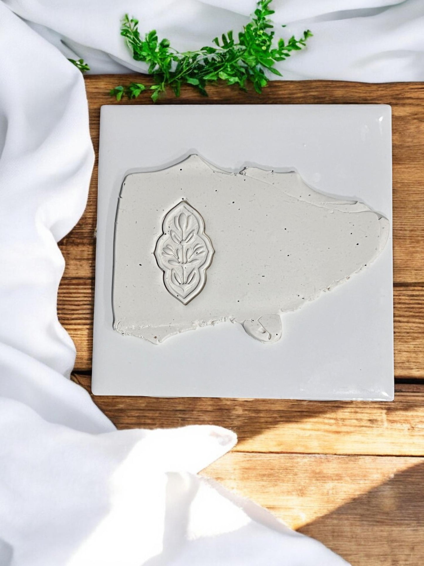Pressed clay slab showing cutter impression with leaf-style design