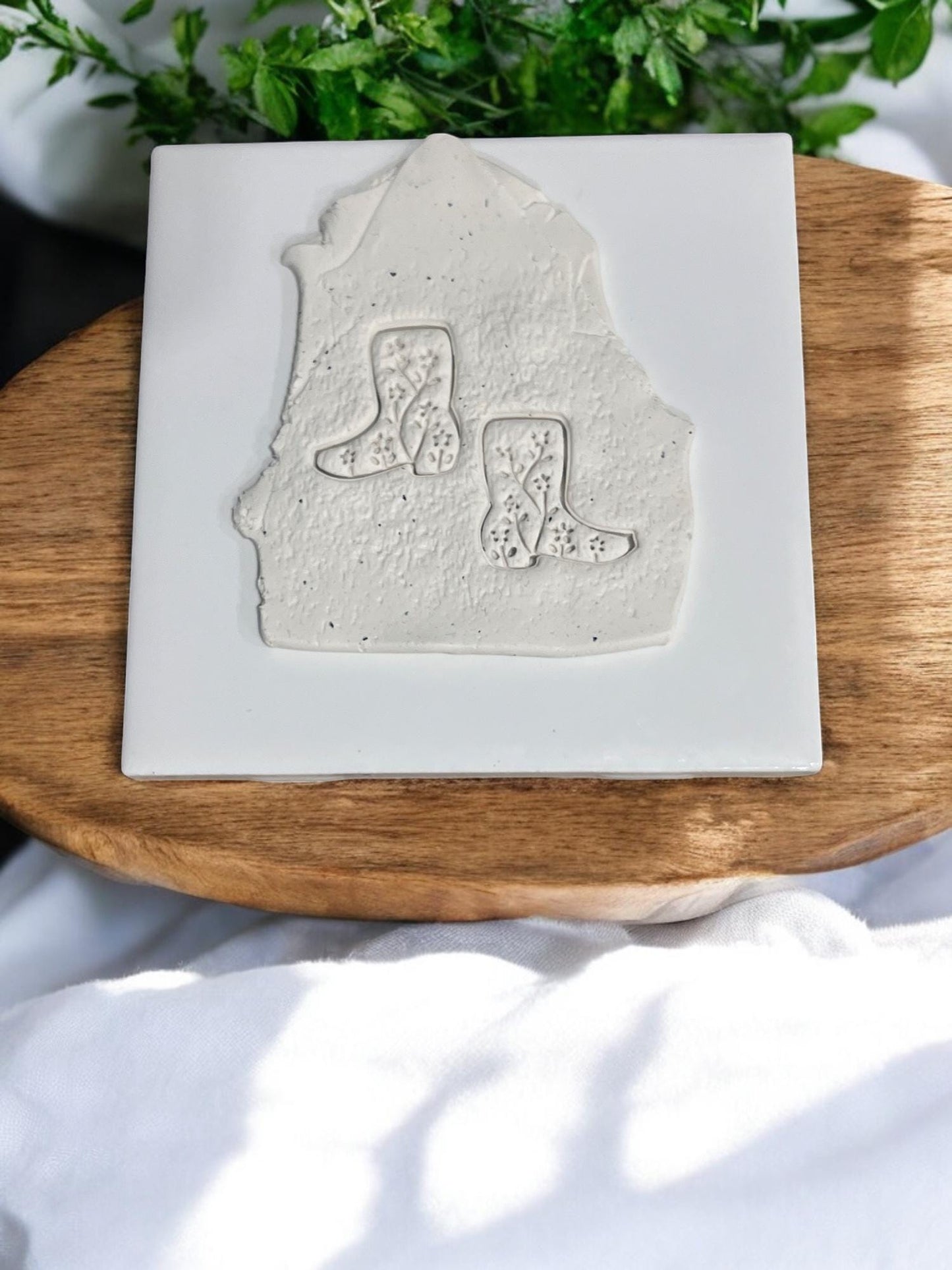 Western boot emboss design pressed into clay slab on ceramic tile