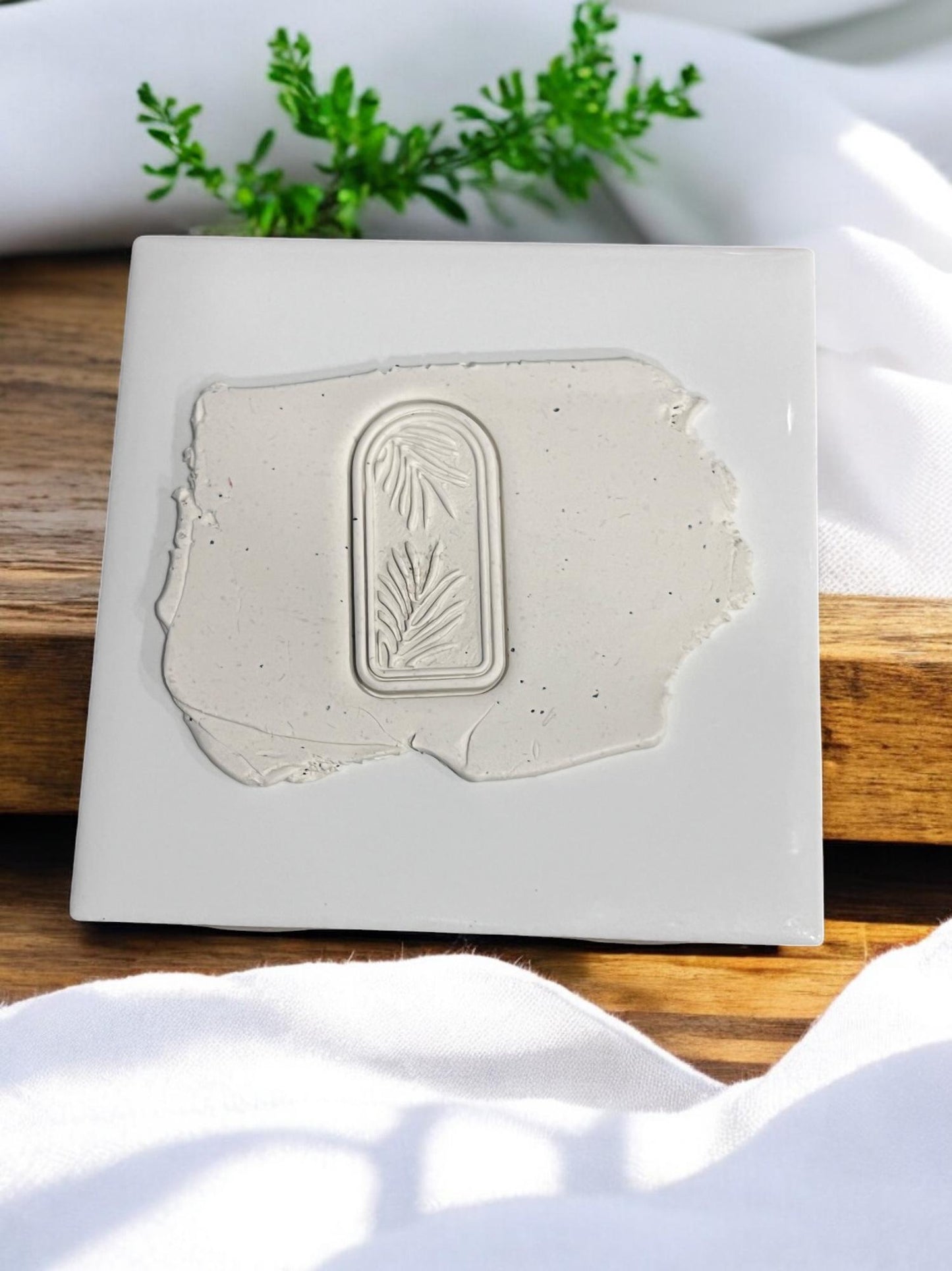 Arched cutter imprint with palm leaves on clay slab