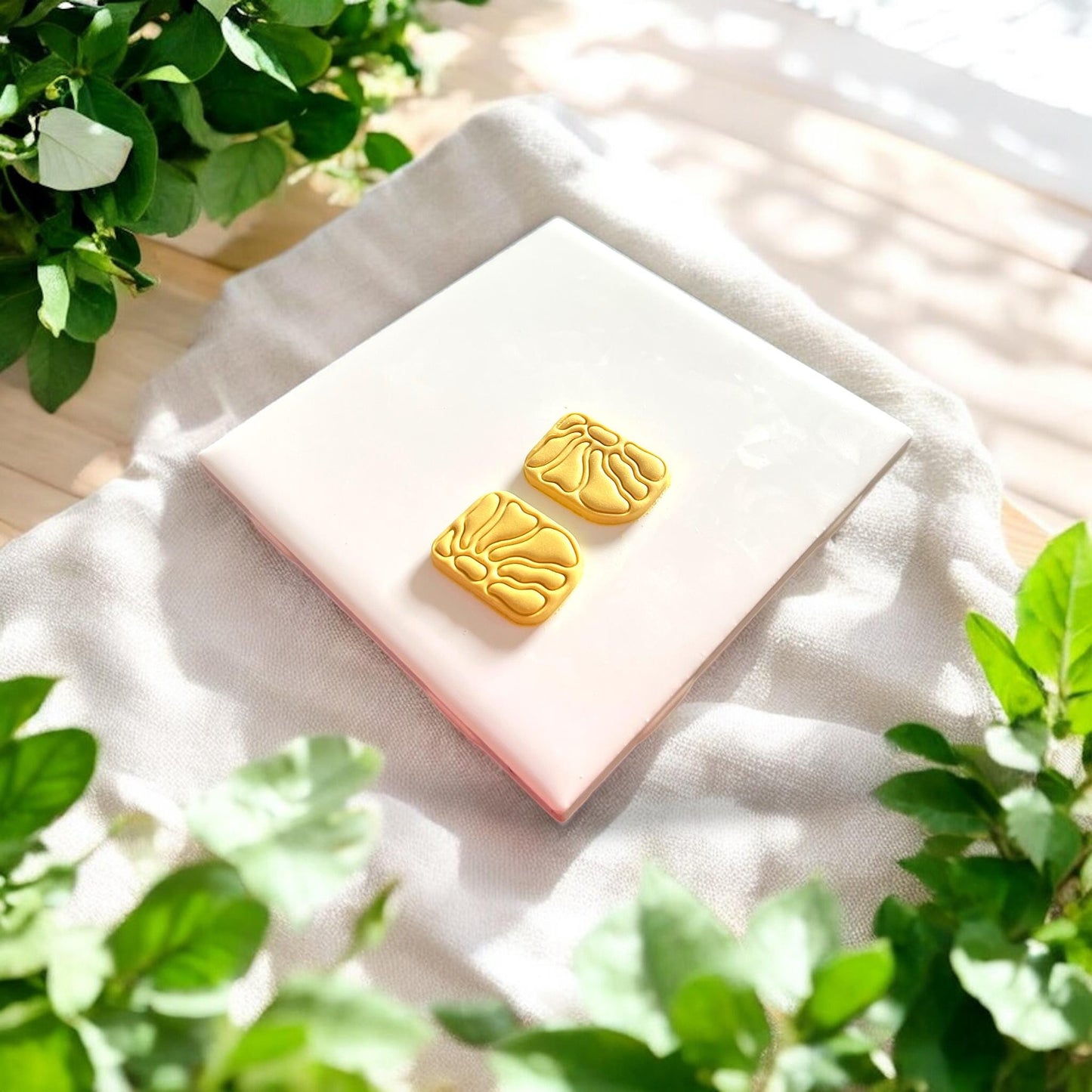 two raised clay floral shapes side by side