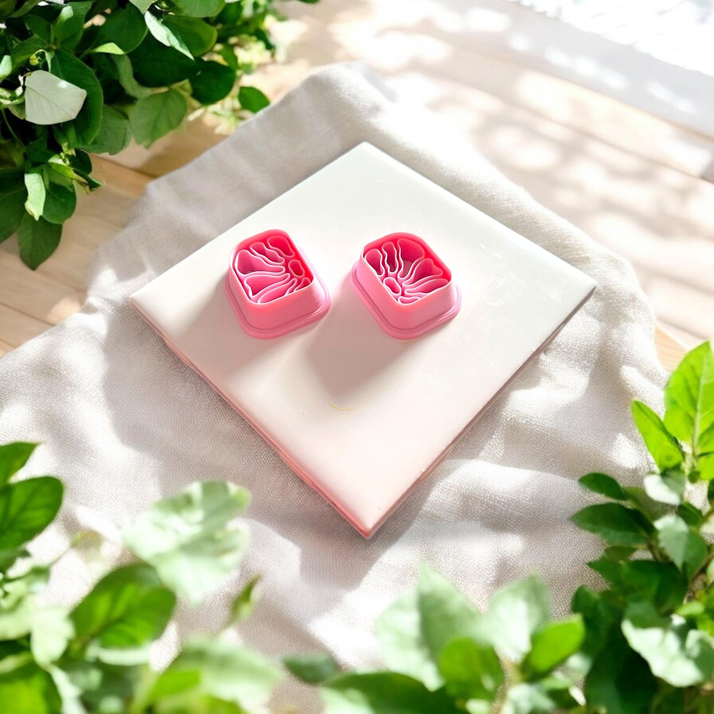 mirrored floral clay cutter pair on white tile