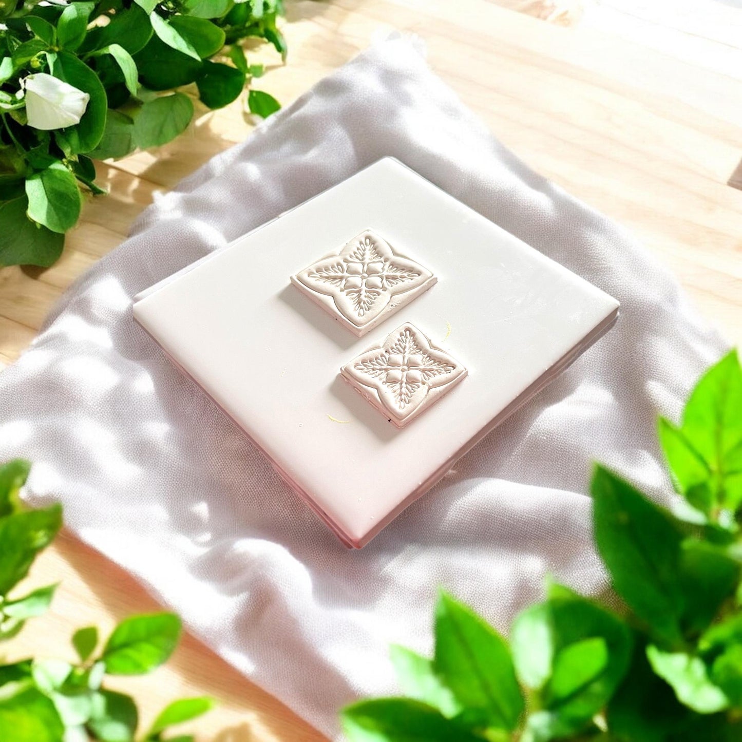 two beige clay pieces with embossed tile designs