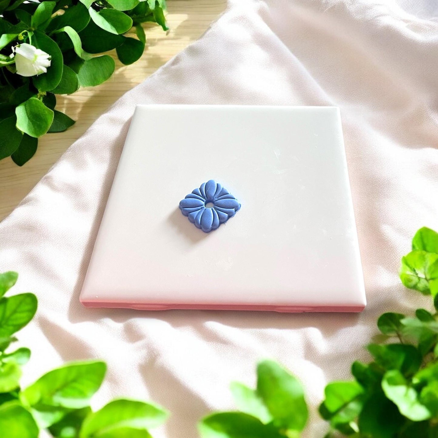finished floral clay piece on white ceramic tile