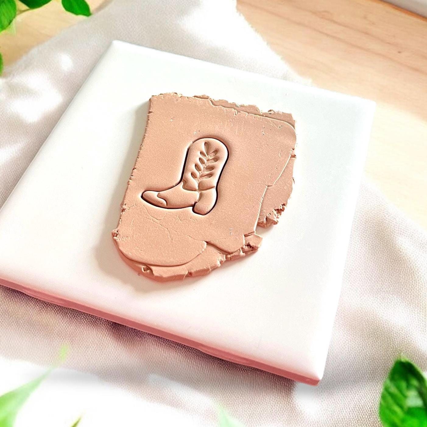 clay impression of a cowboy boot with ivy design