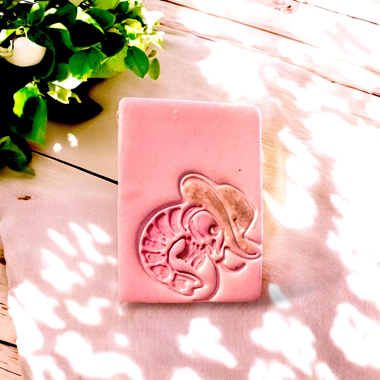 A funny little cowboy lobster with a detailed hat, shown close up, perfectly cut from pink clay.