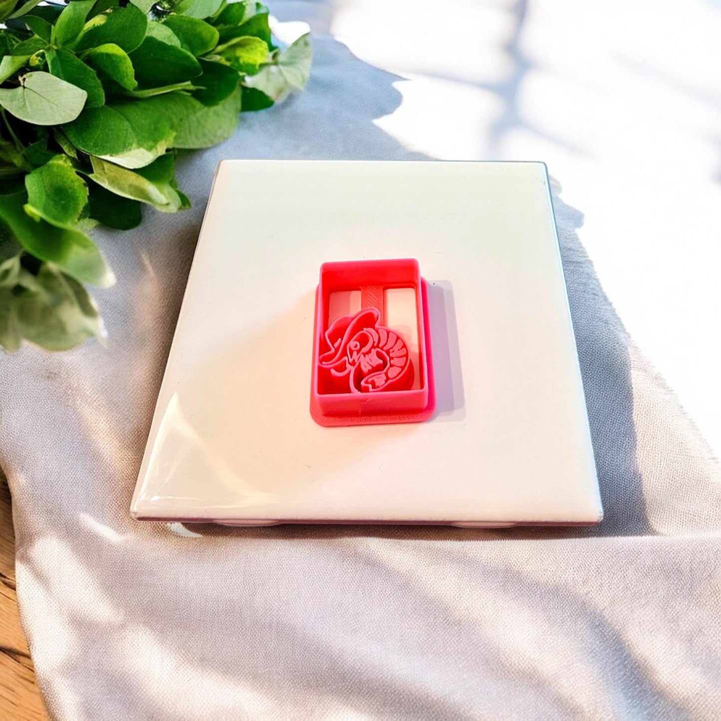The cowboy shrimp cutter with arch frame shown solo on a white ceramic tile.