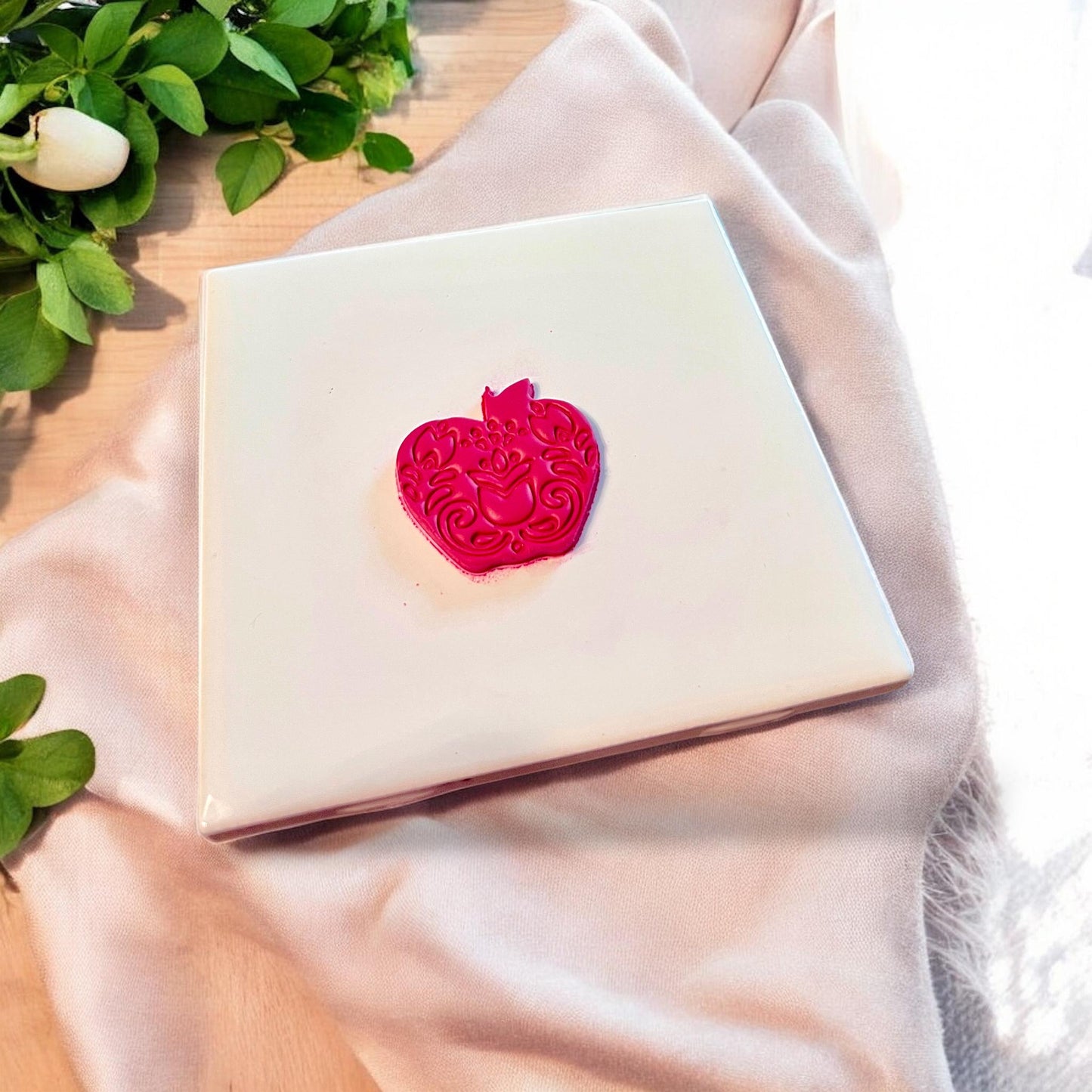 Finished floral apple shape cut from clay with intricate embossing and clean lines