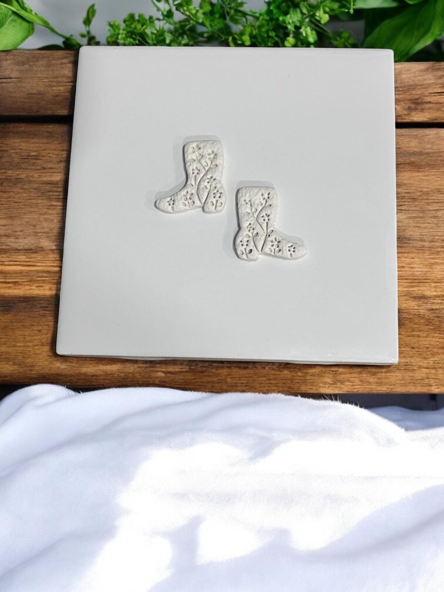 Finished clay boot shapes with embossed floral details