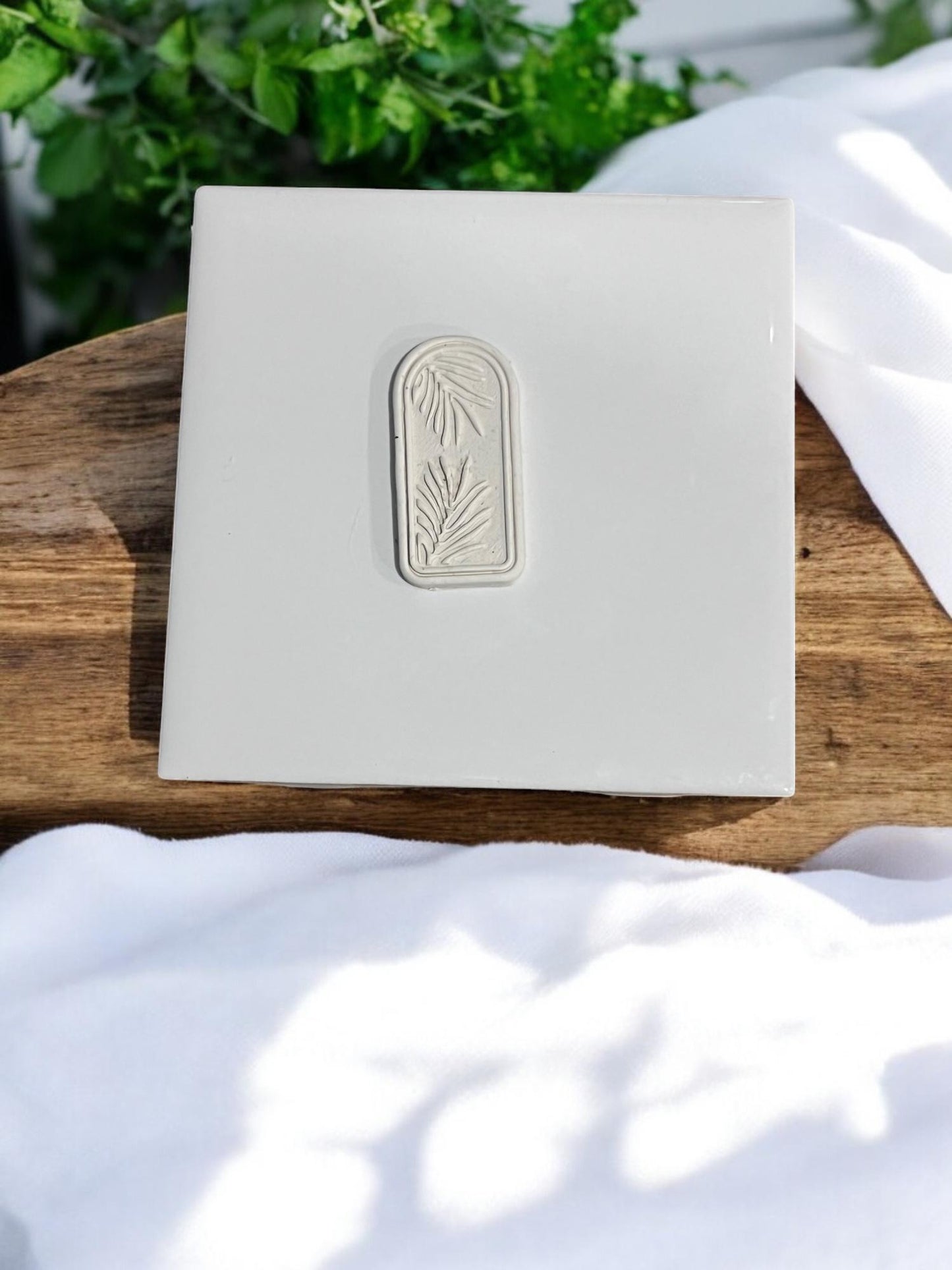 Palm leaf design visible on clay
