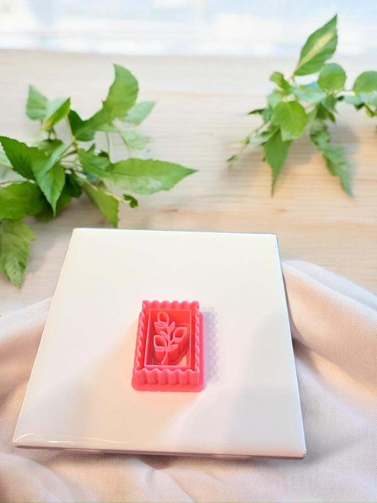 Pink lemon stamp clay cutter shown solo on white tile with leafy background and natural lighting.