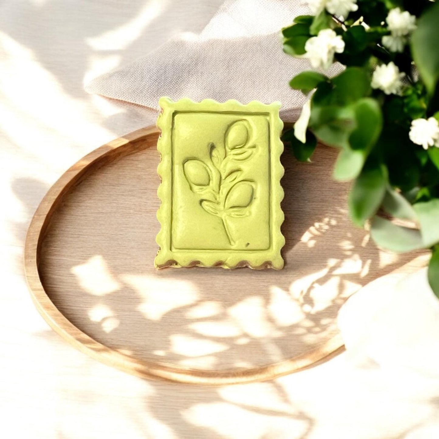Final green lemon impression with realistic leaf details on a wooden tray, surrounded by soft floral light.
