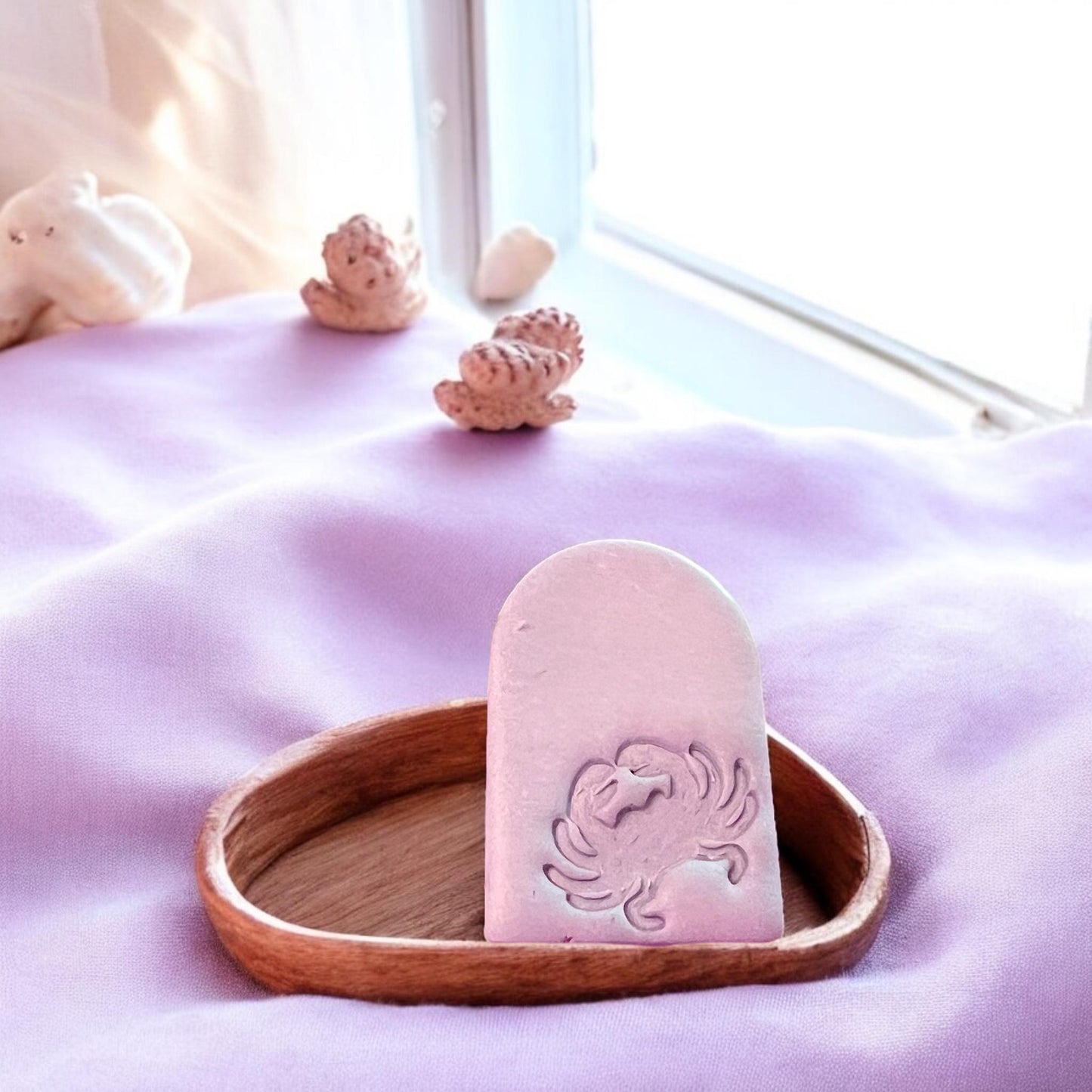 Coastal-styled crab arch earring piece placed on a wooden dish with seashell props, perfect for beach vibes.