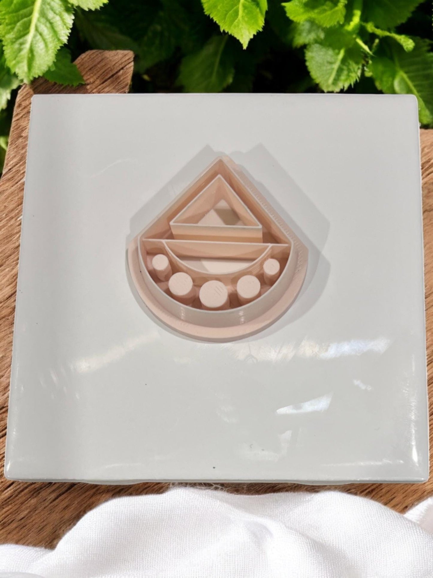 Nude PLA geometric clay cutter with modern triangle and half-moon design on tile