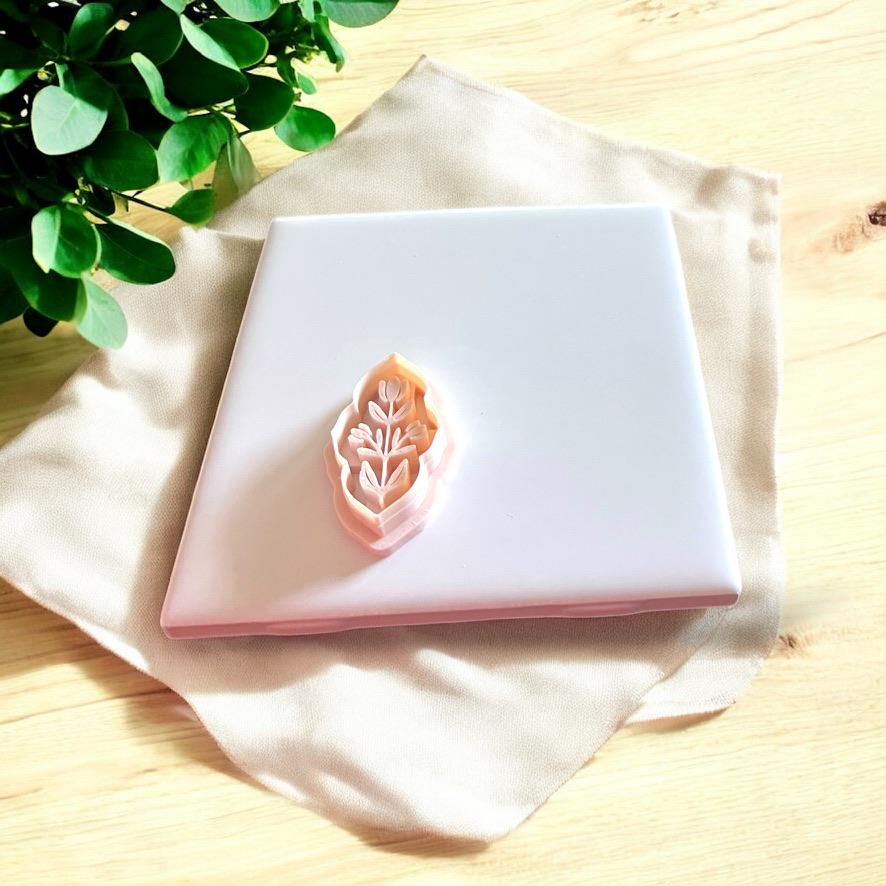 Embossed clay cutter shown next to matching pressed clay result