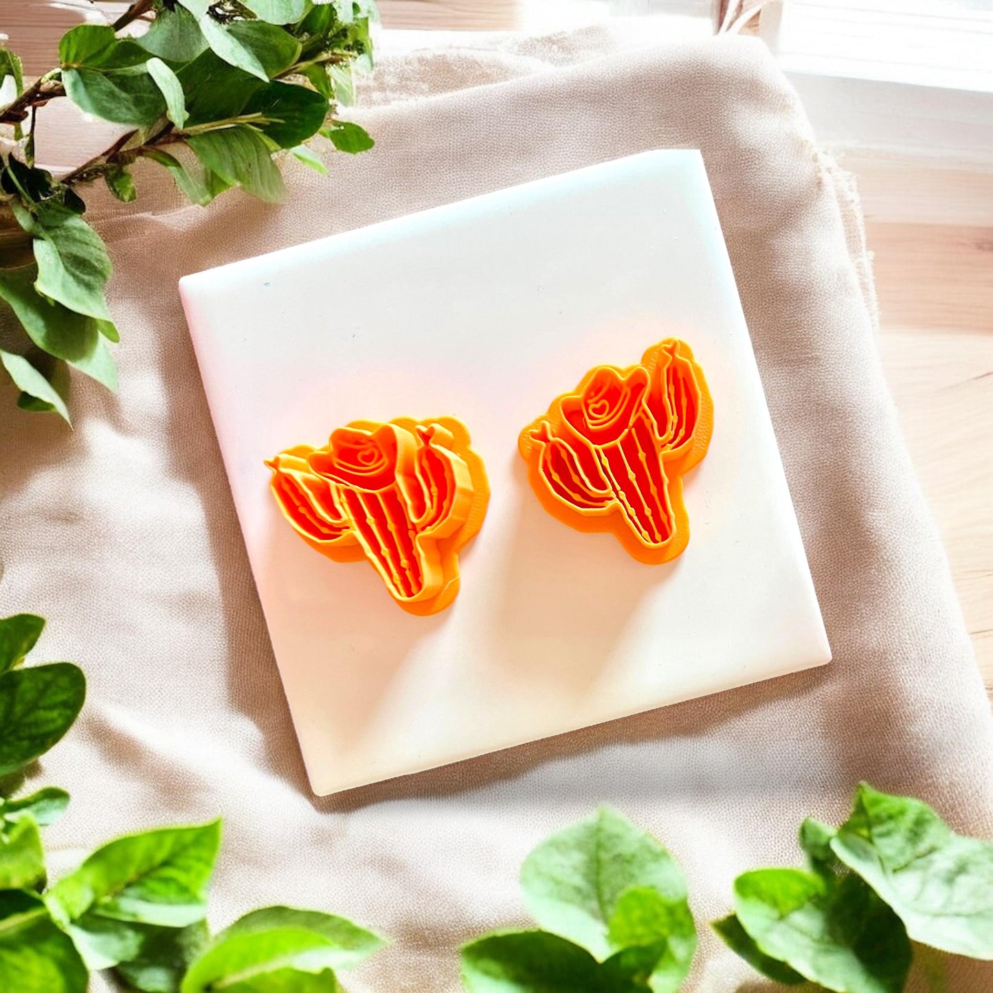 Two orange cowboy cactus cutters on display showing matching shapes and details.