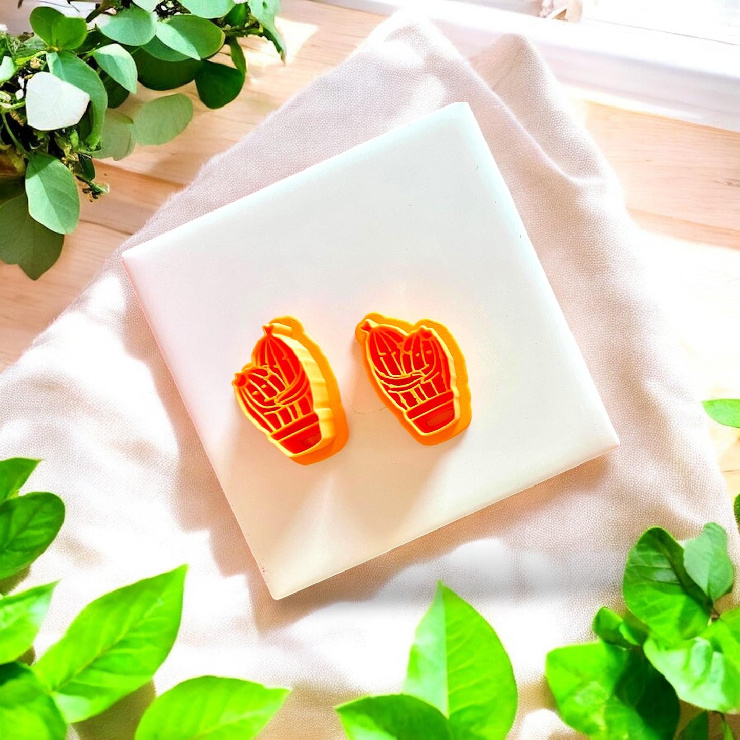 Two orange cactus cutters displayed on white tile, perfect for earring designs