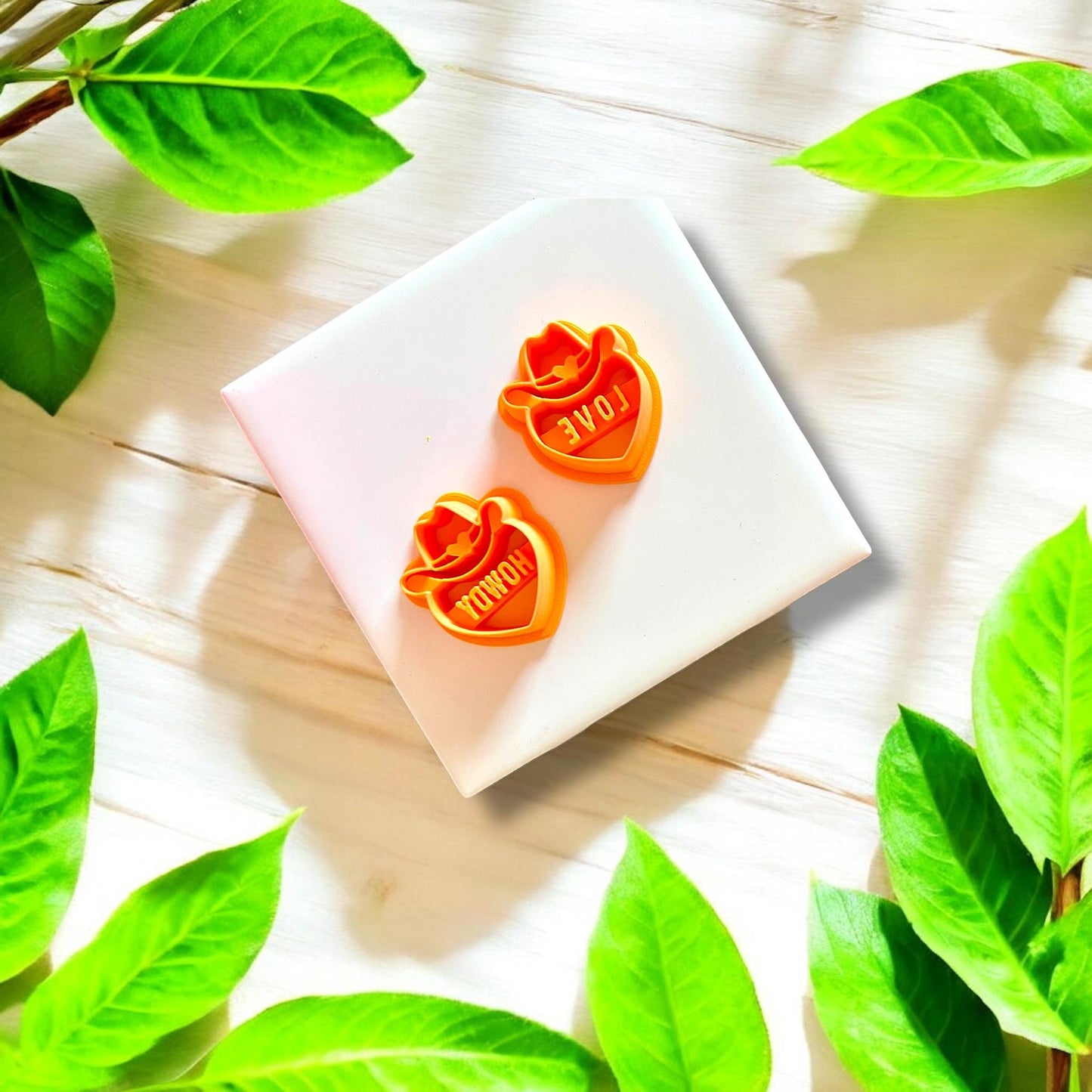 Set of polymer clay cutters shaped as cowboy hats over hearts with "Howdy" and "Love" text, displayed on a white background.