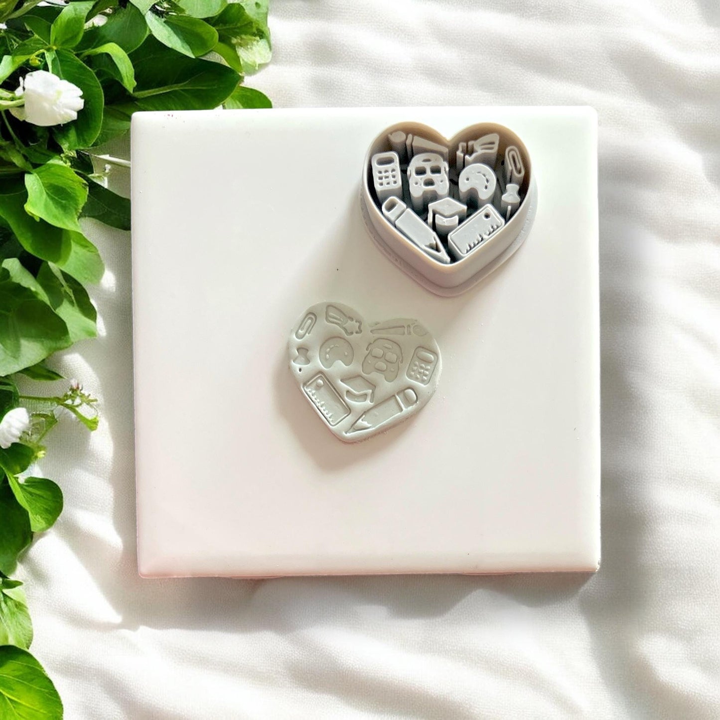 Finished clay shape beside heart-shaped cutter showing all school-themed elements