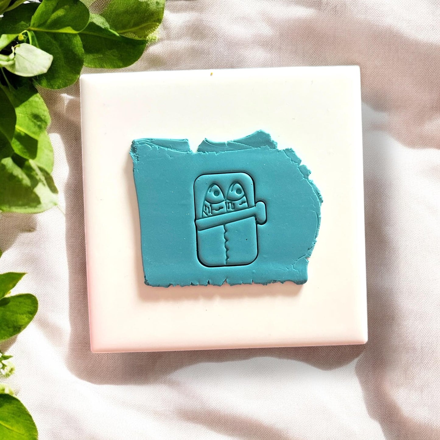 Sardine can polymer clay cutter on raw clay slab