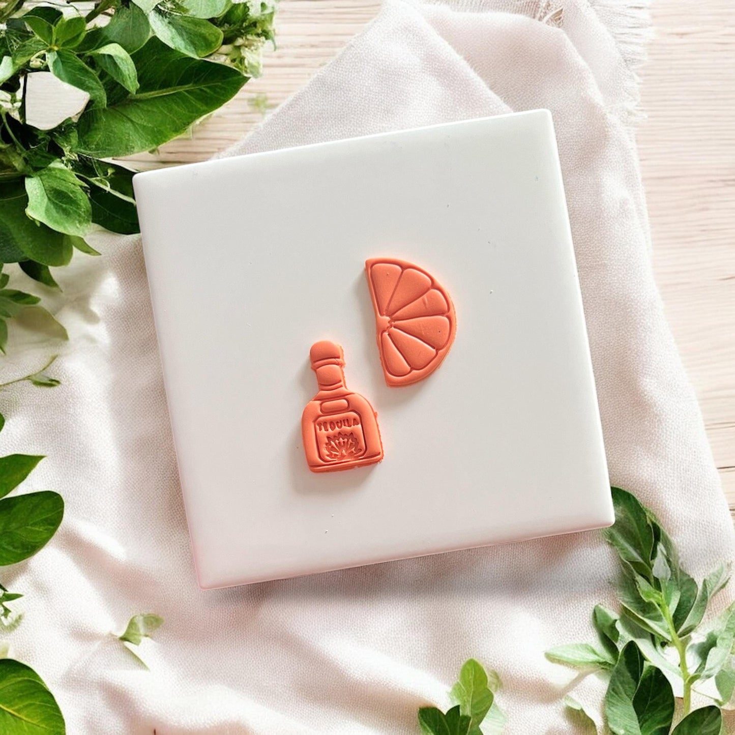 Finished tequila and lime clay earring pieces on white background