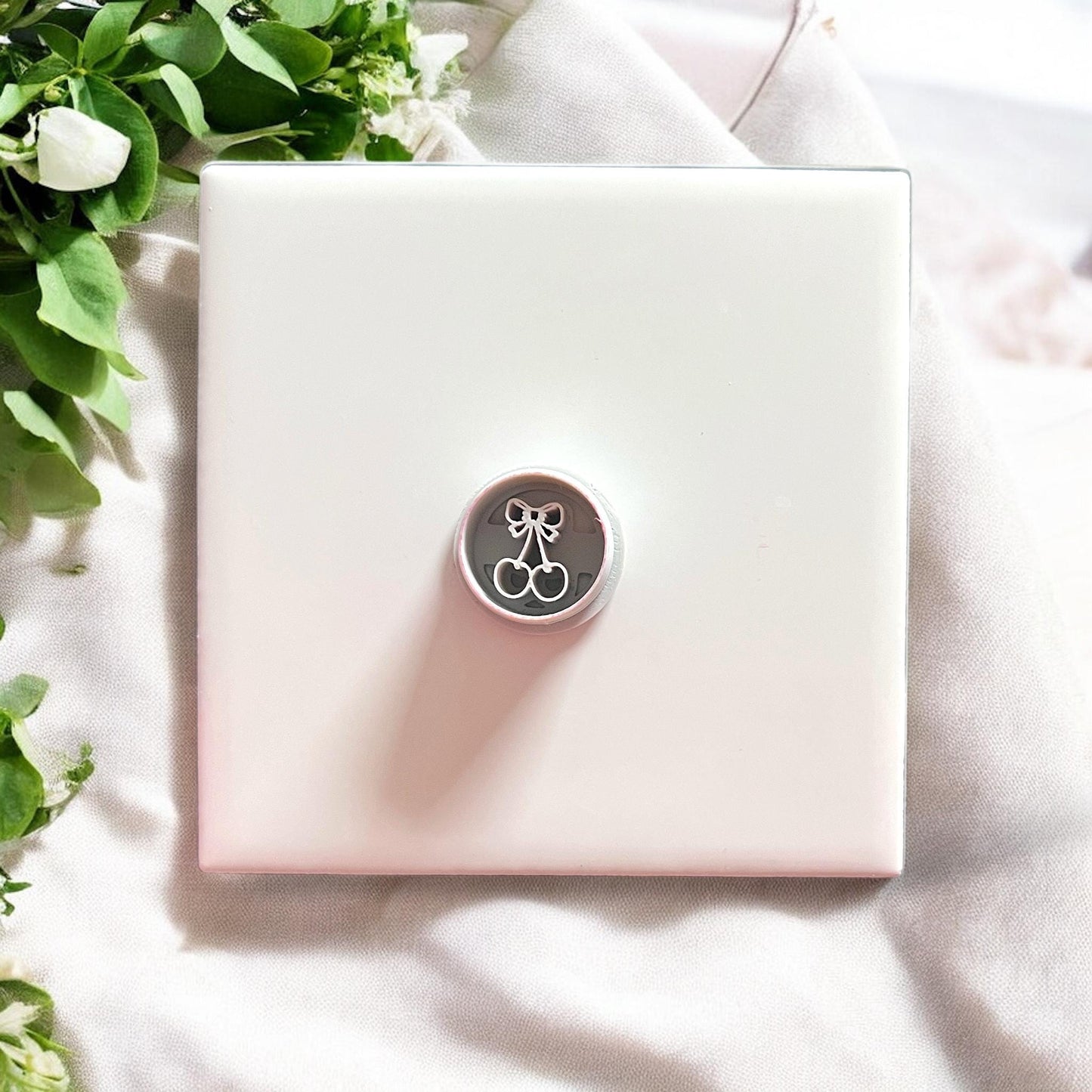 Cherry bow circle cutter shown on white tile with natural lighting