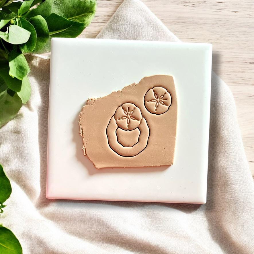 A coastal-inspired earring cutter set featuring a sand dollar top with a drop base, ideal for summer polymer clay earrings.