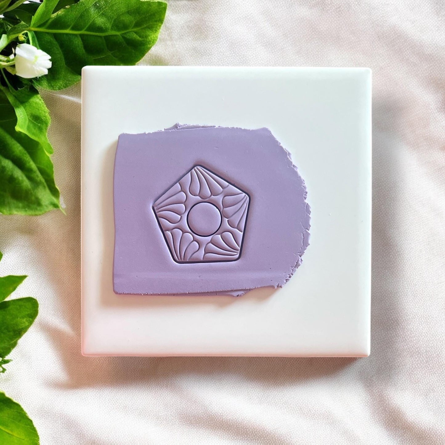 Polymer clay cutter featuring an ornate floral motif within a geometric shape, ideal for creating dangle earrings.