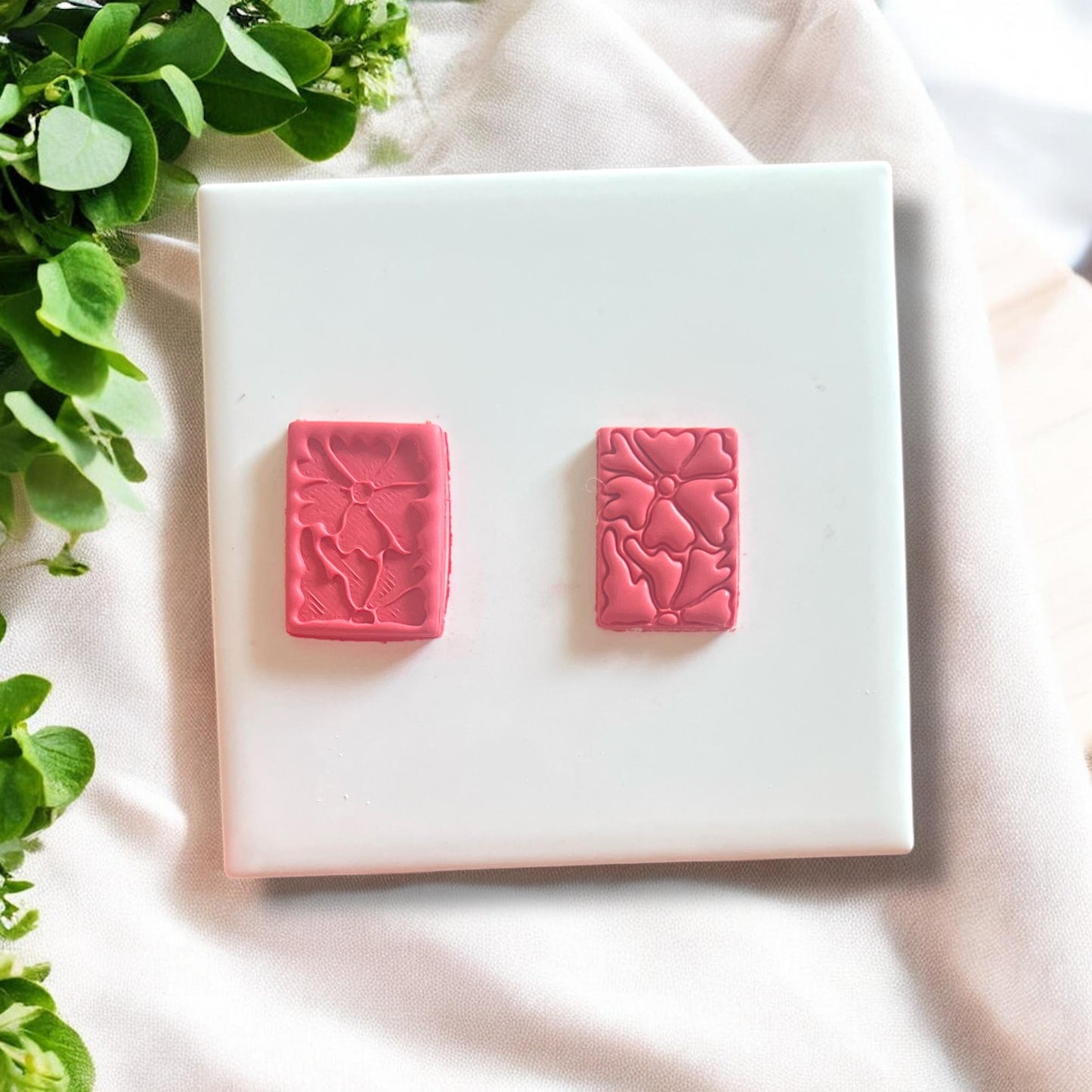 Impression of the Matisse flower cutter on a slab of polymer clay, showcasing detailed design elements.