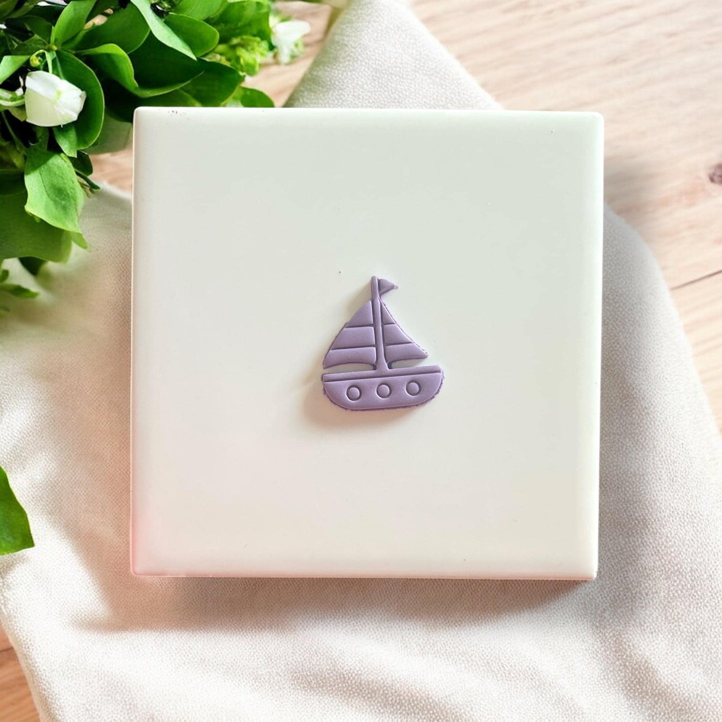 Dainty sailboat clay cutout in lavender, showcasing its smooth edges and perfect details for earrings.