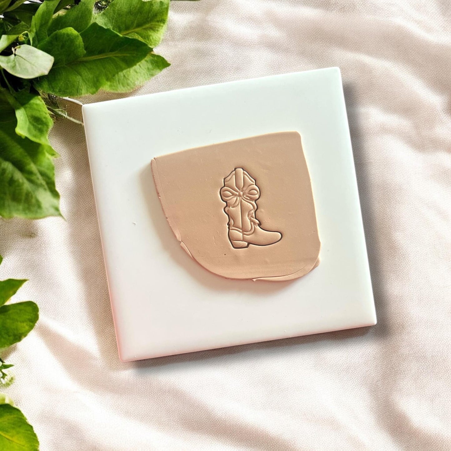 Front view of the cowboy boot polymer clay cutter featuring a coquette bow design.