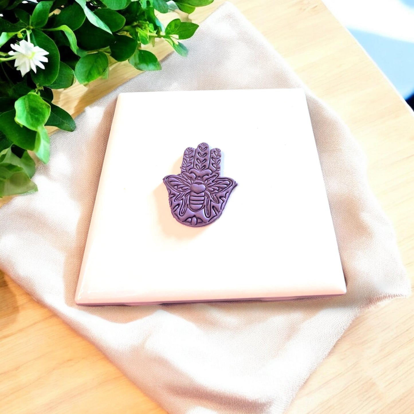 Detailed view of the hamsa hand cutter used for making spiritual earrings.