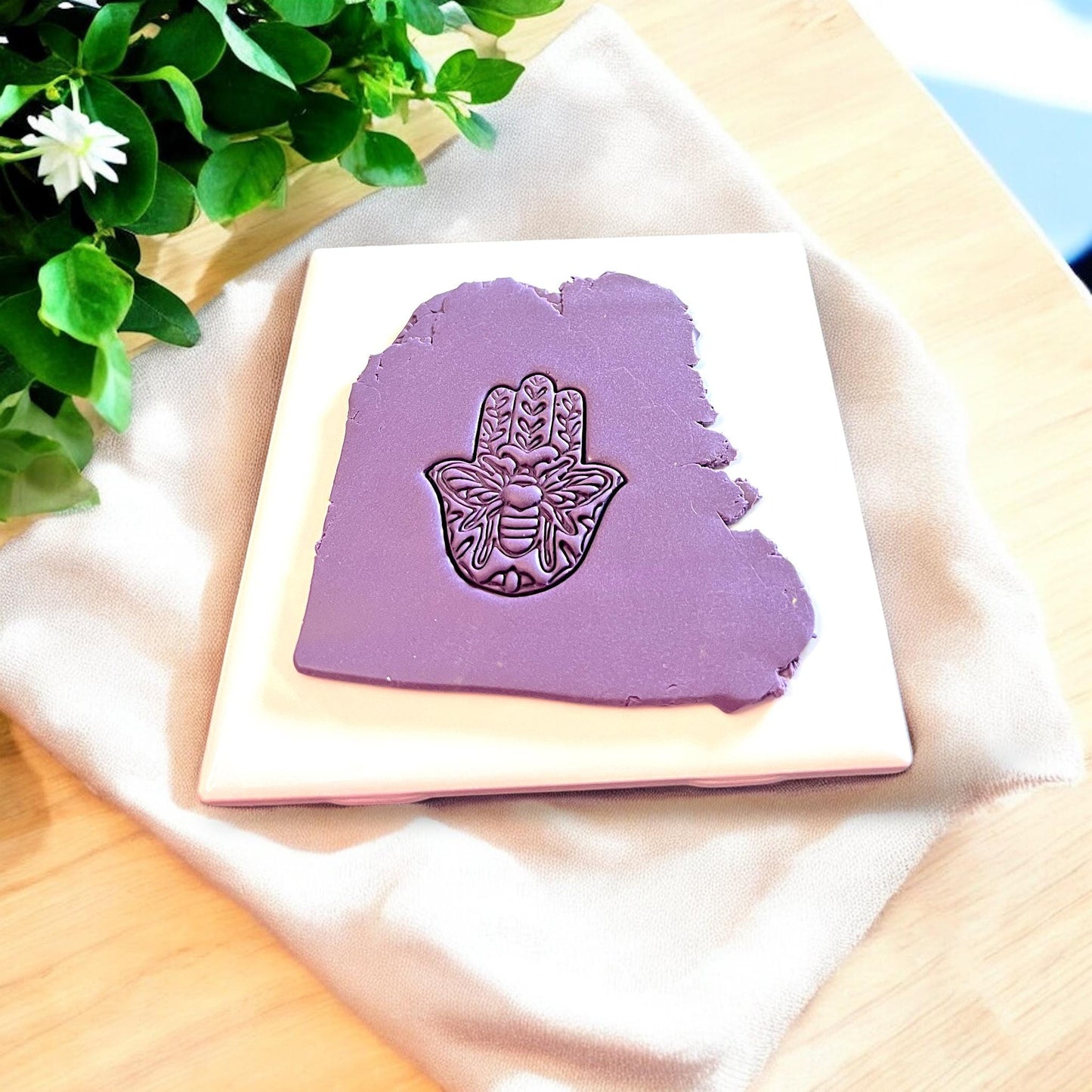 A 3D-printed hamsa-shaped cutter designed for crafting polymer clay jewelry.