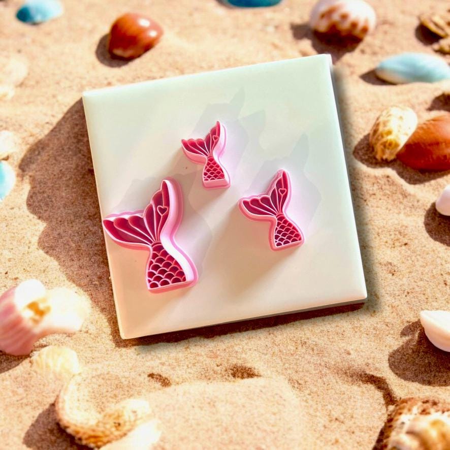 Cutter alongside a clay cutout of a mermaid tail, ideal for beach-themed jewelry designs.